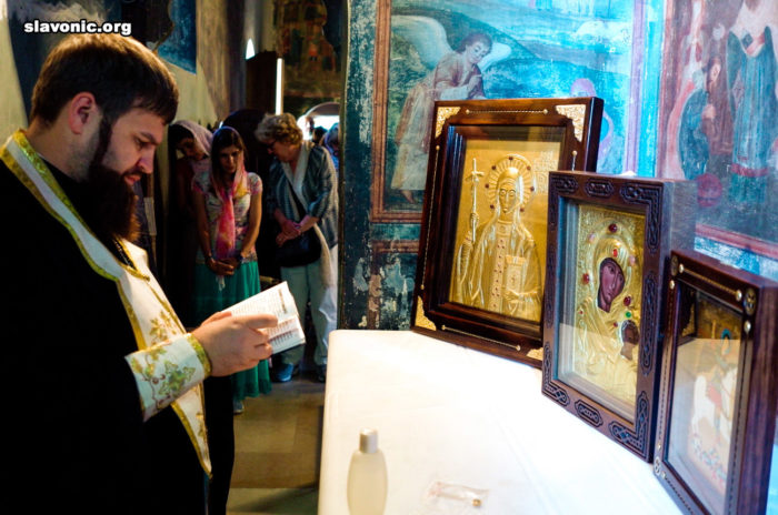 Архимандрит Александр (Беля) освящает иконы на мощах святой Нины